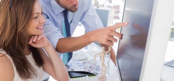 Man pointing something to his partner on screen in creative office Man pointing something to his partner on screen in creative office